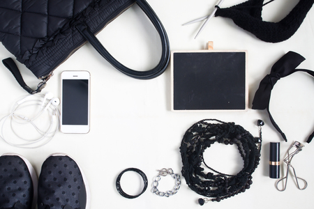 Woman Accessories, cosmetics, shoulder bag, note pad and smartphone in black concept, top view, flat layの写真素材
