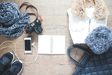 Flat lay photography with cellphone, travel accessories, essential items for woman, Overhead view, top view on wood backgroundの写真素材