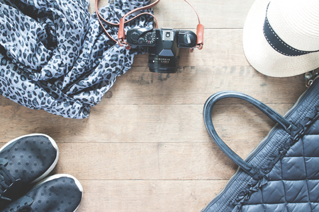 Flat lay photography with camera, travel accessories, essential items for woman, Overhead view, top view on wood backgroundの写真素材