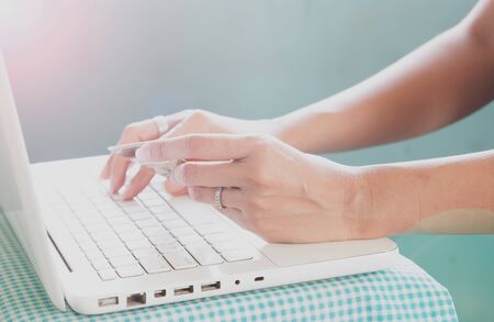 Hands holding credit card and using laptop. Online shoppingの写真素材