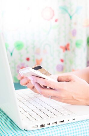 Hands holding smartphone, credit card and using laptop. Online shoppingの写真素材