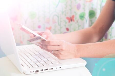 Hands holding smartphone, credit card and using laptop. Online shoppingの写真素材