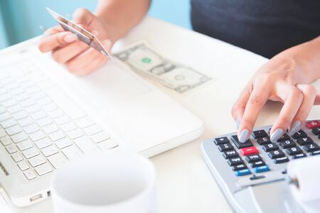 Hands holding credit card, using laptop and calculator. Online shoppingの写真素材