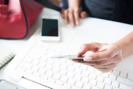 Hands holding credit card and using laptop. Online shoppingの写真素材