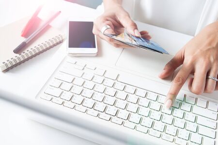 Hands holding credit cards and using laptop. Online shoppingの写真素材