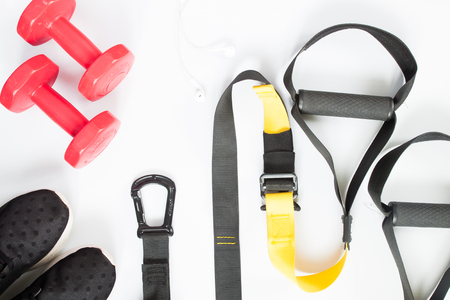 Flat lay of red dumbbells, black sneakers and sport equipment on white background. Sport wear, Sport accessories, top viewの写真素材