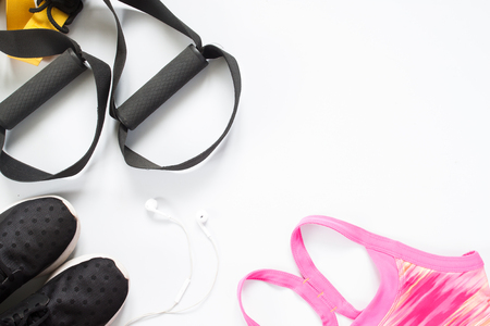 Flat lay of earphone, red dumbbells and sport equipment on white background. Sport wear, top viewの写真素材