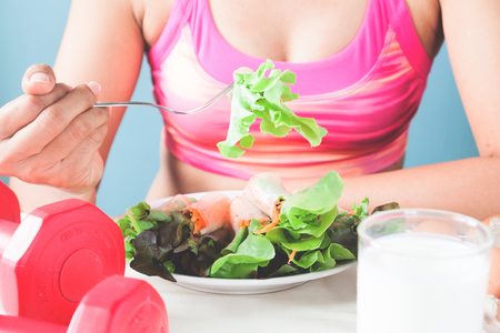 Female fitness eating fresh salad and milk, Healthy lifestyle conceptの写真素材