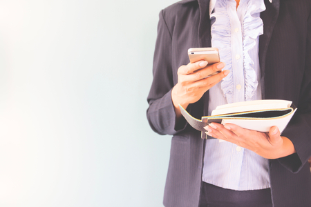 Business woman in dark suit holding mobile phone and notebook, Business concept with copy spaceの写真素材