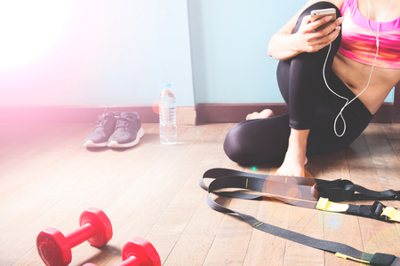 Fitness female in black pants and pink sport bra relaxing after workoutの写真素材