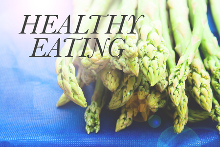fresh green asparagus tips on blue background, HEALTHY EATING conceptの写真素材