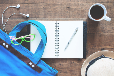 Flat lay set of notebook, pen, girl accessories and a cup of coffee , Top view on wood backgroundの写真素材