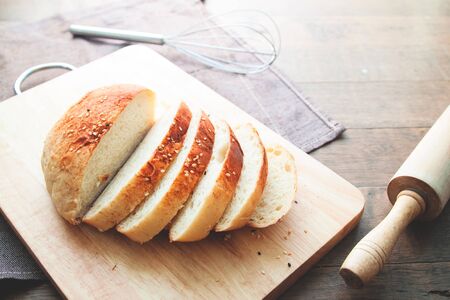 Sliced homemade bread with sesame on wood backgroundの写真素材