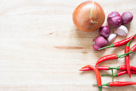 Fresh vegetables on wood plate, onion, garlic and red chilli with copy spaceの写真素材