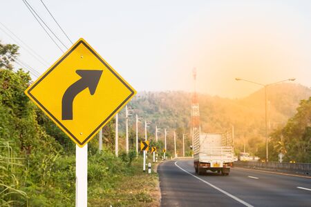 Turn right road sign on country road with sunlight