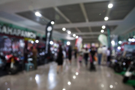 Blurred background of retail shop with customers in exhibition hallの写真素材