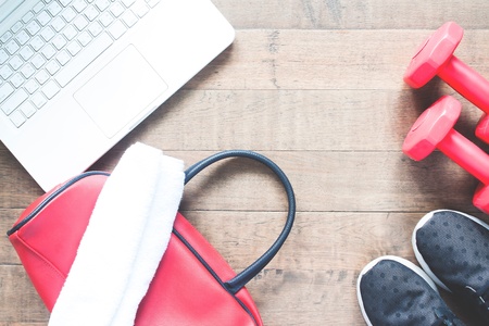 Flat lay of laptop conputer and sport equipments on wood background. Workout and Healthy lifestyle, top viewの写真素材