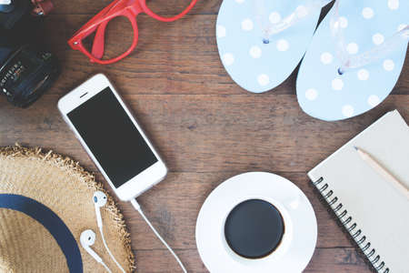 Lifestyle concept with smartphone, coffee cup, sandal, hat and empty notebook, Flat lay and Top view
