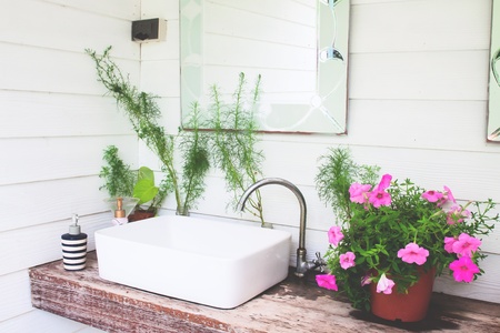 Washbasin with pink flowers in home garden, White and beautiful conceptの写真素材