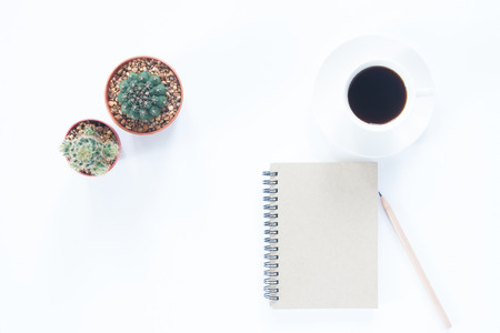 Notebook with pencil coffee cup and cactus on white backgroundの写真素材