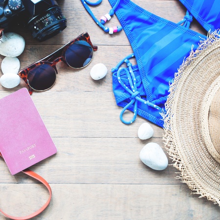 Summer items for women, beach summer collection on wood background