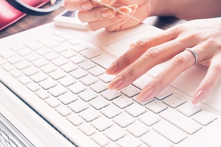 Close up of female fingers using laptop and credit card, Working woman and Online shopping concept, Selective focusの写真素材