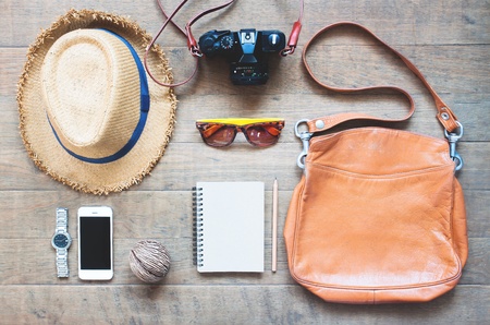 Outfit of traveler, camera, mobile device, sunglassses. Overhead shot of essentials for traveler,...