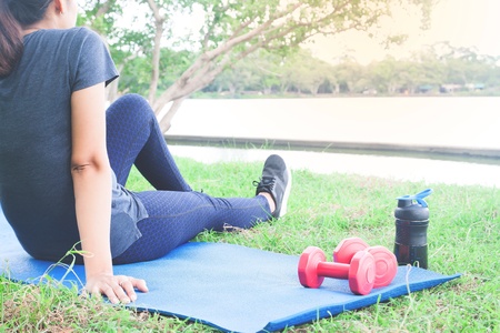 Asian woman in sport clothing sittng after exercise in the park, Healthy lifestyle conceptの写真素材