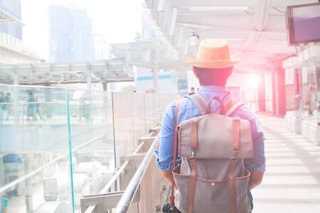 Asian backpacker walking on  modern walk way in city, Travel and Lifestyle conceptの写真素材