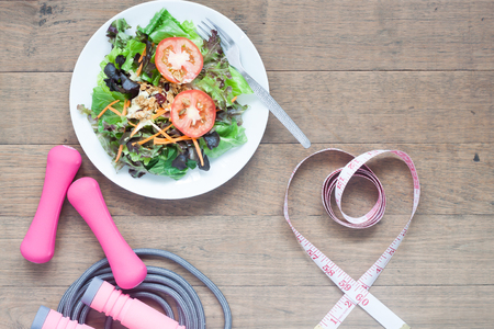 Sport equipments, fresh salad and measuring-tape in heart shape, Healthy lifestyle conceptの写真素材