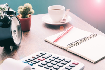 Calculator, notebook, coffee on table, Accounting workspace conceptの写真素材