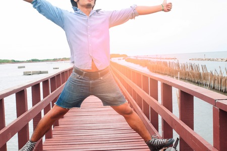 Happy man in casual jeans on wooden bridge, Travel conceptの写真素材