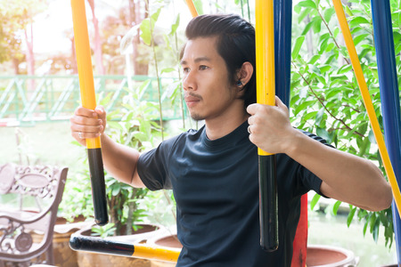 Asian man exercising with training equipment at park, Healthy lifestyle