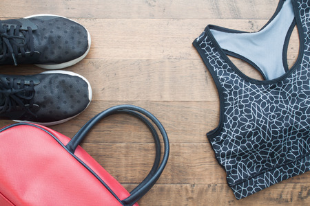 Top view of sport woman items on wooden background, Sport shoes, sport bra and bagの写真素材