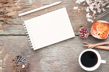 Craft notebook, pencil, cup of coffee on antique wooden table, Flat lay fall and winterの写真素材
