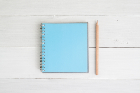Blue pastel color notebook with pencil on vintage white wooden background, Flat layの写真素材