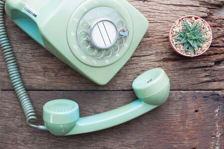 Flat lay vintage style with vintage phone and Cactus plant on wooden tableの写真素材