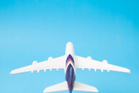 Creative flat lay of travel comcept with airplane on blue color background with copy spaceの写真素材
