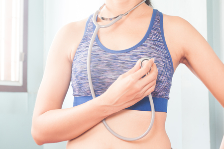 Sport woman holding stethoscope on her body, Healthcare conceptの写真素材