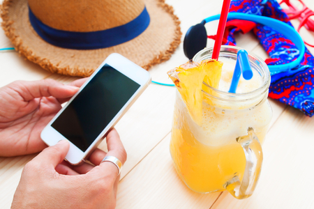 Summer holiday concept with woman using mobile phoneの写真素材