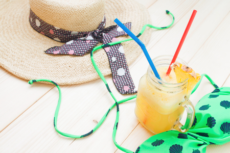 Pineapple smoothie with woman's accessories for summer vacation, Beach holiday conceptの写真素材