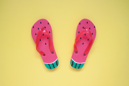 Flat lay of fashion sandals, watermelon on yellow color background