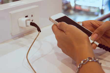 Woman hands using mobile phone while charging, Danger, Technology conceptの写真素材