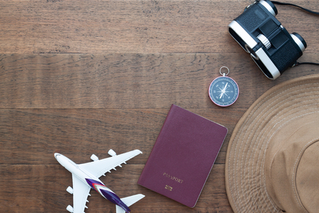 Creative flat lay travel concept, passport book, compass and binoculars on wooden background with copy spaceの写真素材