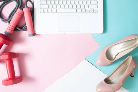 Flat lay of workspace laptop computer, fitness equipment and lady's shoes on pastel color background, Healthy lifestyle and beauty conceptの写真素材