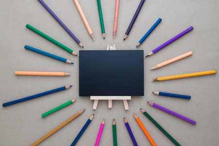 Creative flat lay of black board and colour pencils, Top view with space for textの写真素材