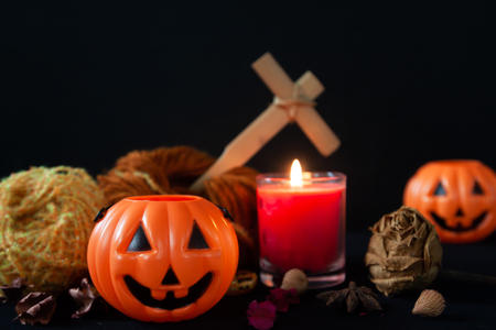 Orange pumpkin as a head and burning candles on a black background, Halloween partyの写真素材