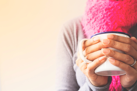Woman hands holding a mug of coffee or tea, Toned pictureの写真素材