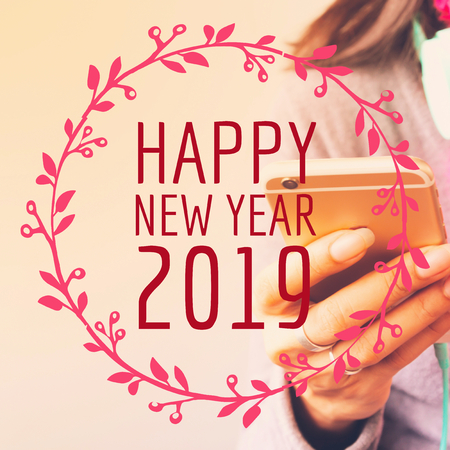 Happy New Year 2019 typography on image of woman using mobile phoneの写真素材