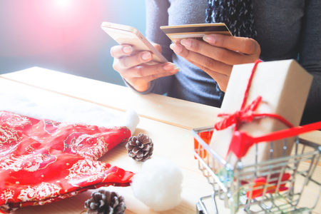 Woman using mobile phone and credit card. Christmas shopping onlineの写真素材